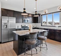 kitchen featuring stainless steel appliances, a kitchen island, hanging light fixtures, and a kitchen breakfast bar