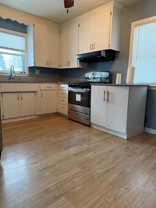 kitchen featuring stainless steel range with gas cooktop, white cabinetry, and light hardwood / wood-style floors