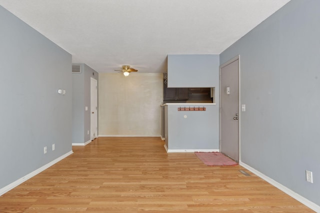 interior space with ceiling fan, a textured ceiling, and light hardwood / wood-style flooring