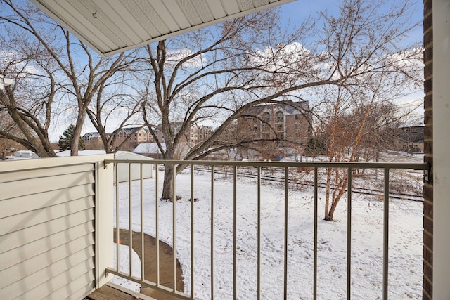 view of snow covered back of property