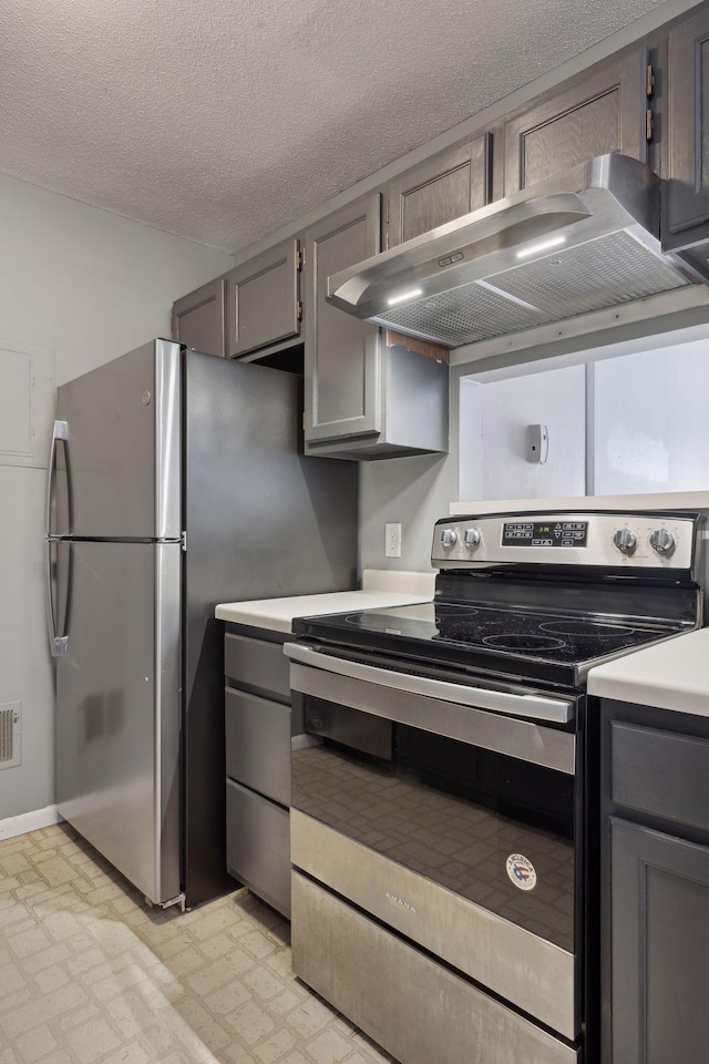 kitchen featuring exhaust hood, stainless steel appliances, a textured ceiling, and gray cabinets