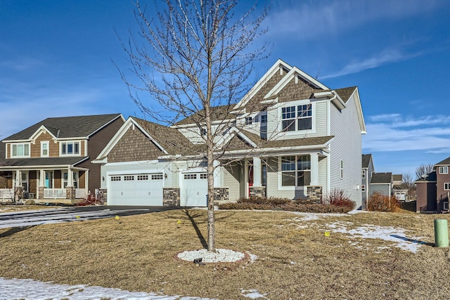 craftsman inspired home featuring a garage, a lawn, and a porch