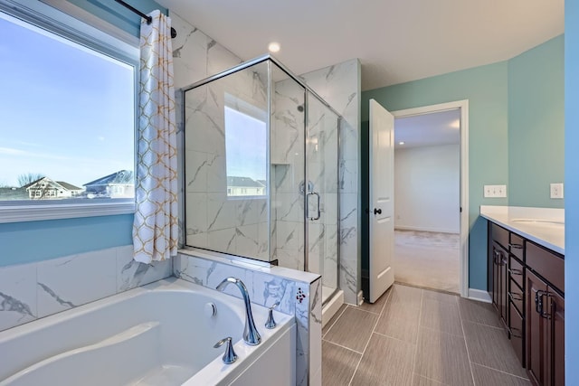 bathroom featuring shower with separate bathtub and vanity