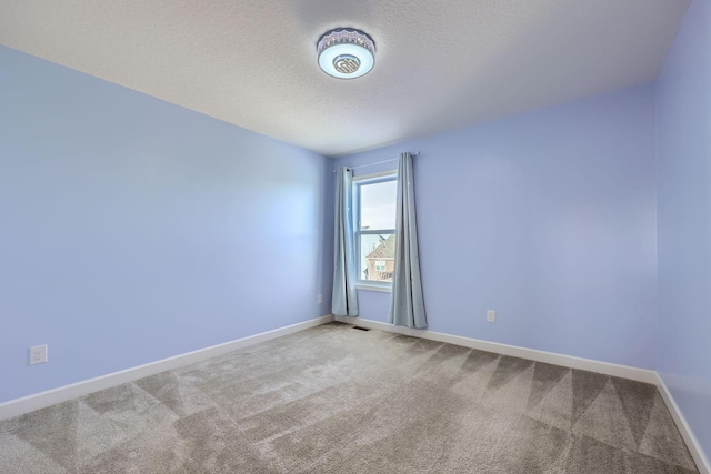 carpeted spare room featuring a textured ceiling