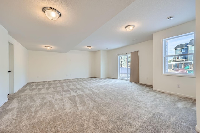 carpeted spare room with a textured ceiling