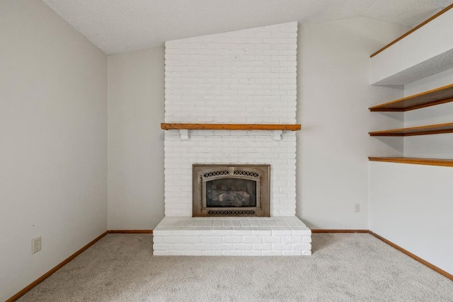 unfurnished living room featuring lofted ceiling, carpet flooring, a brick fireplace, and a textured ceiling