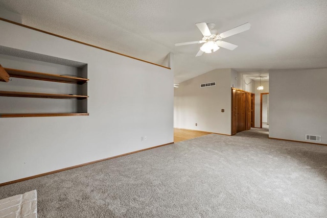 carpeted empty room featuring vaulted ceiling and ceiling fan