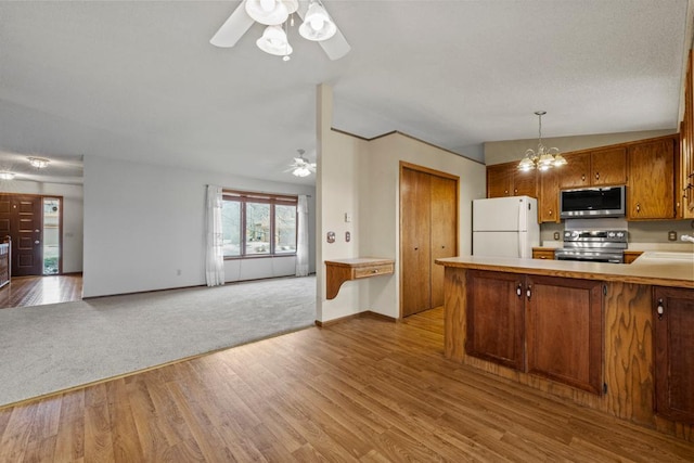 kitchen featuring hanging light fixtures, stainless steel appliances, light hardwood / wood-style floors, ceiling fan with notable chandelier, and kitchen peninsula