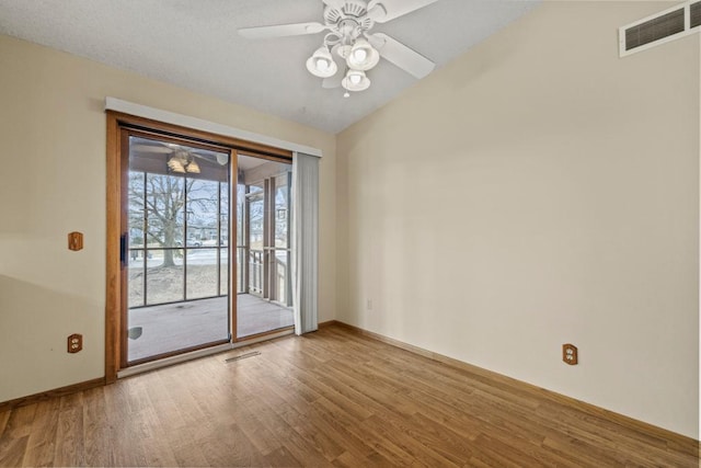 doorway featuring hardwood / wood-style flooring, vaulted ceiling, and ceiling fan