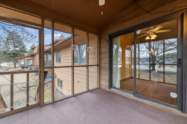 unfurnished sunroom featuring vaulted ceiling, a wealth of natural light, and ceiling fan