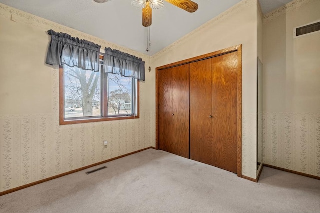 unfurnished bedroom featuring a closet, ceiling fan, and carpet