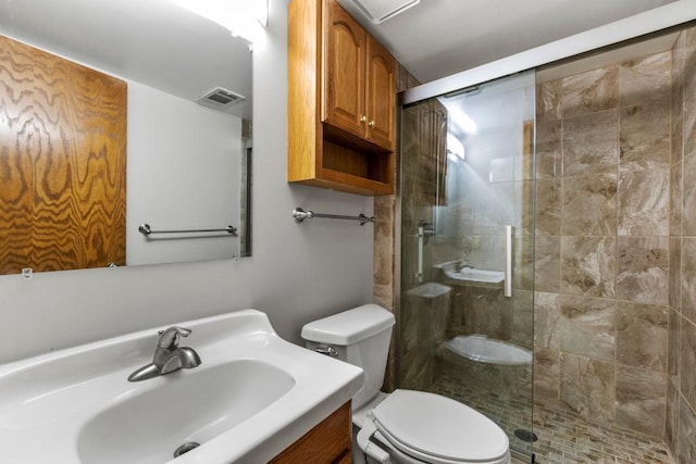 bathroom featuring vanity, toilet, and an enclosed shower