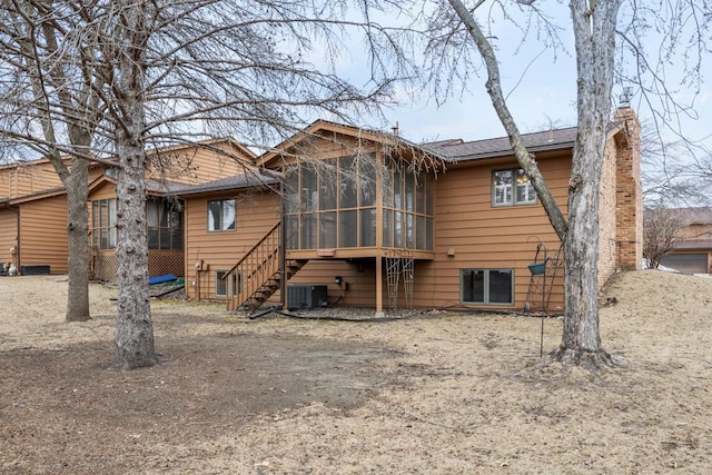 back of house with a sunroom and central AC