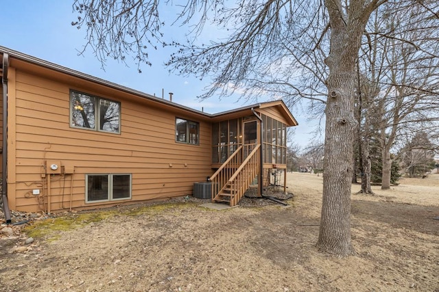 rear view of property with a sunroom and central AC