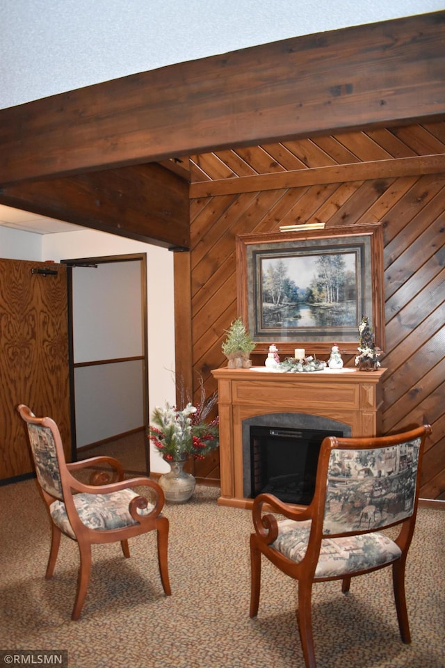 living area with wooden ceiling, beam ceiling, wooden walls, and carpet floors