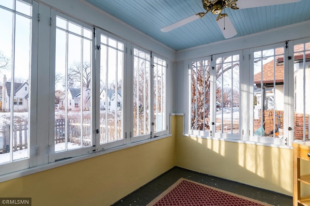 unfurnished sunroom featuring ceiling fan and plenty of natural light