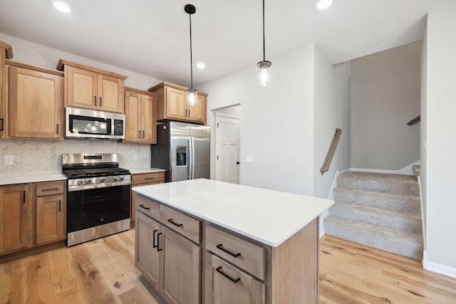 kitchen featuring appliances with stainless steel finishes, decorative backsplash, hanging light fixtures, a center island, and light hardwood / wood-style floors