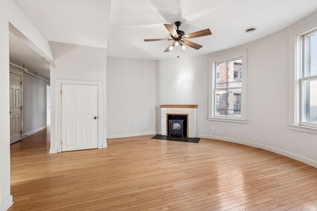 unfurnished living room with light hardwood / wood-style floors, plenty of natural light, and ceiling fan