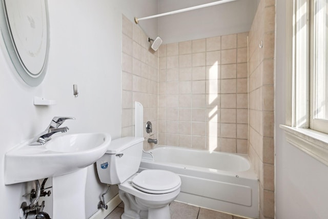 bathroom with toilet, tile patterned flooring, and tiled shower / bath combo