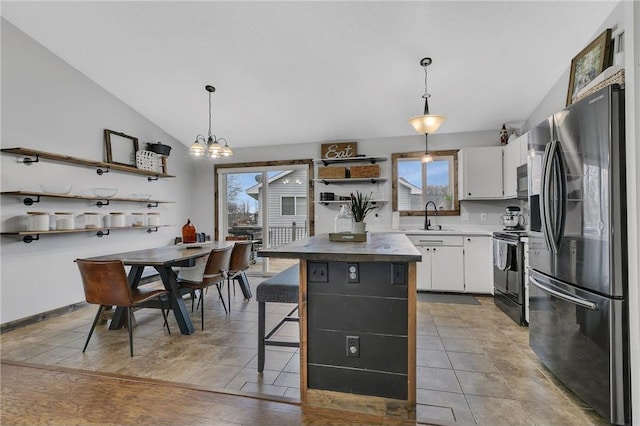 kitchen with white cabinetry, stainless steel refrigerator with ice dispenser, electric stove, hanging light fixtures, and a center island