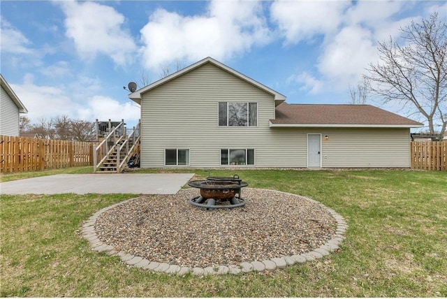 rear view of house featuring a lawn, a fire pit, and a patio