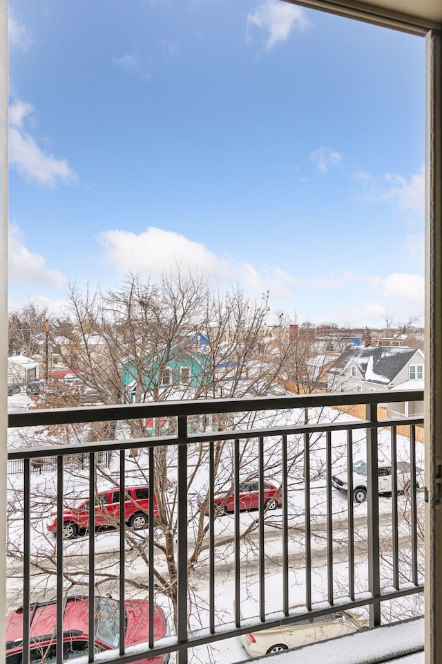 view of snow covered back of property