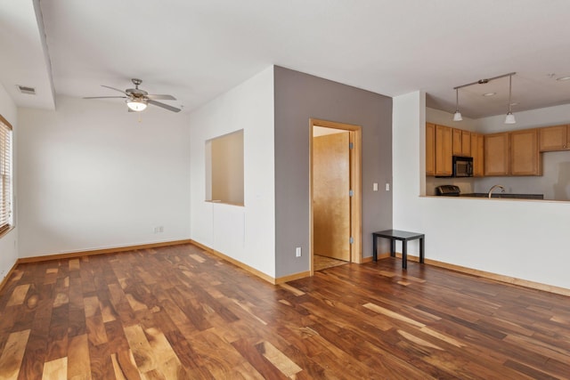 unfurnished living room featuring dark hardwood / wood-style floors and ceiling fan