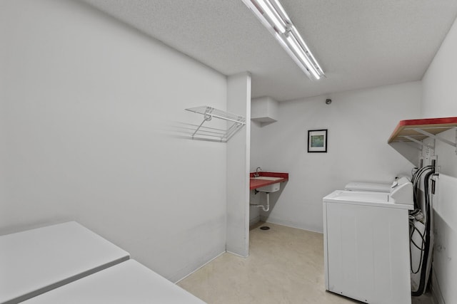 washroom with independent washer and dryer and a textured ceiling