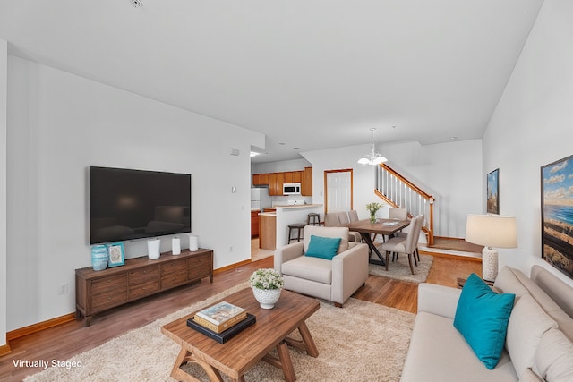 living room with a notable chandelier and light wood-type flooring