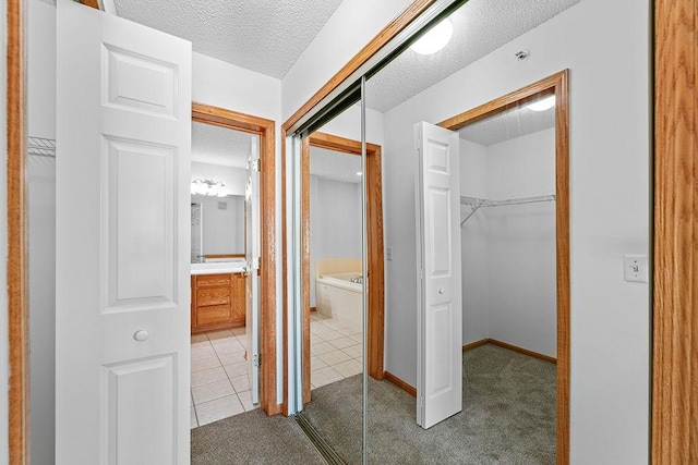 corridor with carpet flooring and a textured ceiling