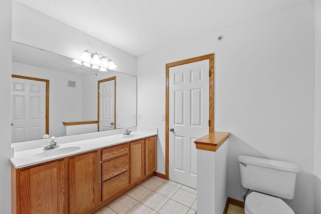 bathroom featuring tile patterned flooring, vanity, a textured ceiling, and toilet