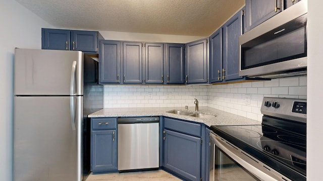 kitchen with stainless steel appliances, sink, backsplash, and blue cabinetry