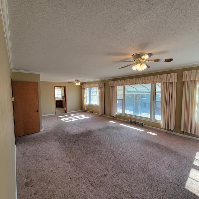 404 Vine St, Fergus Falls, MN 56537 - carpeted spare room with a textured ceiling, ornamental molding, a ceiling fan, and visible vents