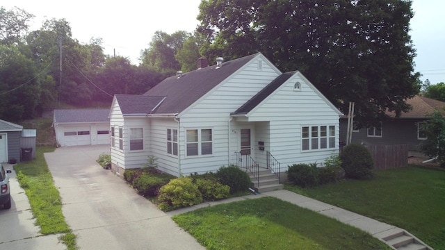 404 Vine St, Fergus Falls, MN 56537 - view of front facade featuring an outdoor structure, a front lawn, and a detached garage