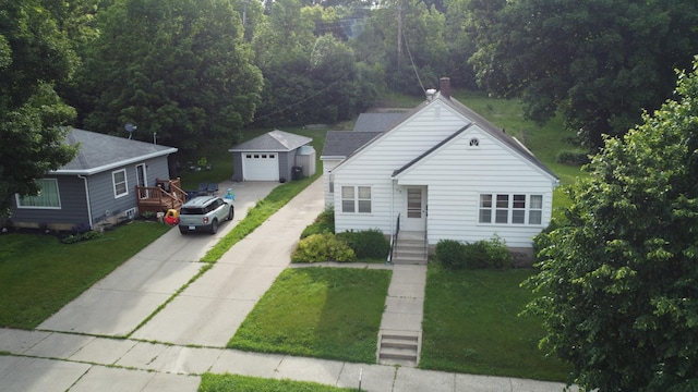 404 Vine St, Fergus Falls, MN 56537 - view of front facade with concrete driveway, an outbuilding, a detached garage, and a front yard
