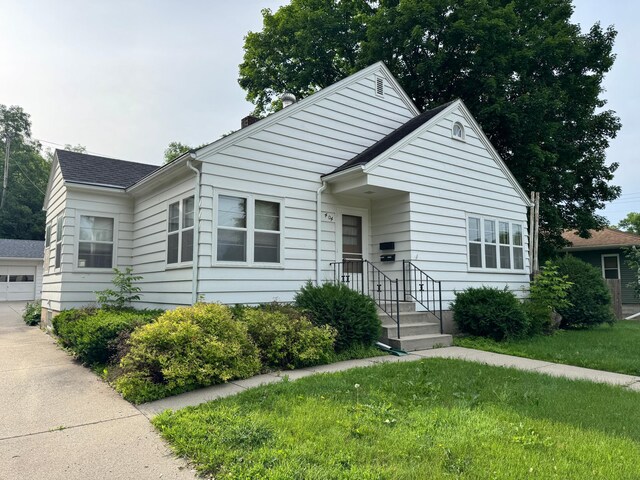 404 Vine St, Fergus Falls, MN 56537 - view of front facade with a chimney, a garage, and a front lawn