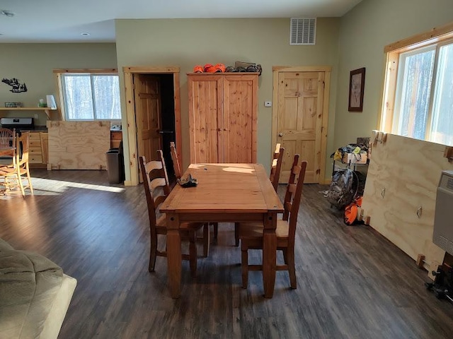 dining area with a healthy amount of sunlight and dark hardwood / wood-style flooring