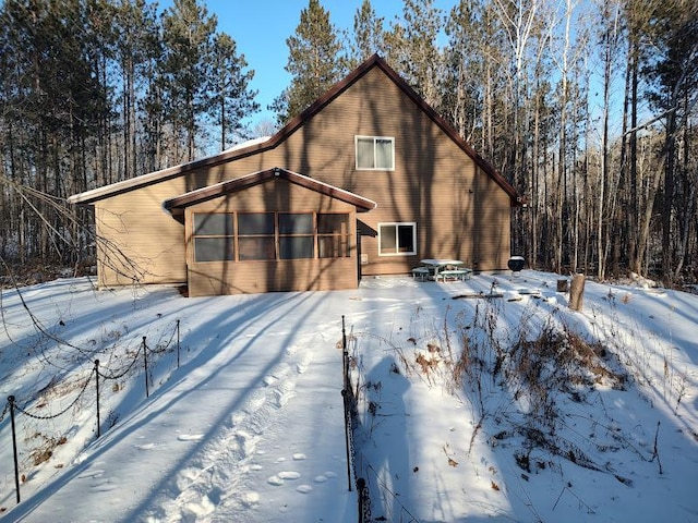 snow covered property featuring a sunroom