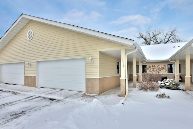 snow covered property featuring a garage