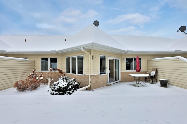 view of snow covered rear of property