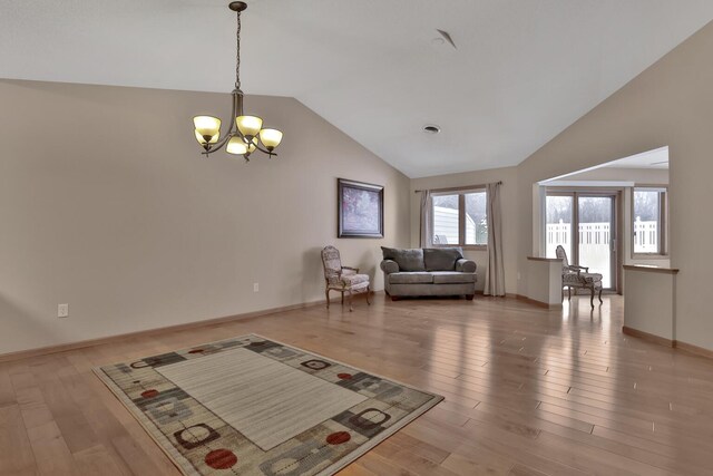 living room with hardwood / wood-style flooring, lofted ceiling, and a notable chandelier