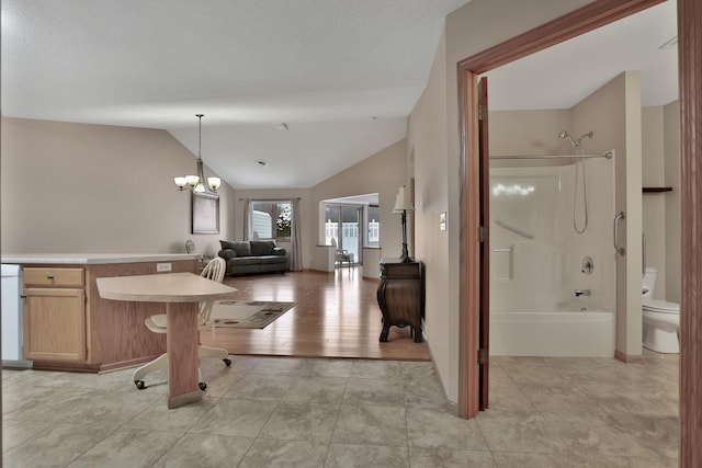 interior space featuring toilet, shower / bath combination, a chandelier, and lofted ceiling