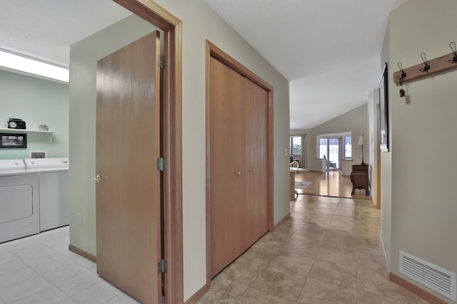 hall with washing machine and clothes dryer and vaulted ceiling