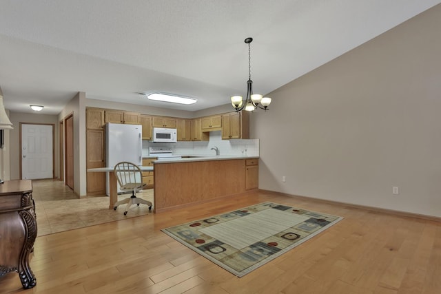 kitchen featuring kitchen peninsula, hanging light fixtures, light wood-type flooring, white appliances, and a notable chandelier