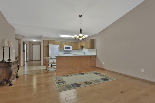 kitchen featuring white appliances, decorative light fixtures, light brown cabinets, kitchen peninsula, and light wood-type flooring