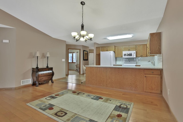 kitchen with kitchen peninsula, white appliances, decorative backsplash, and light hardwood / wood-style flooring