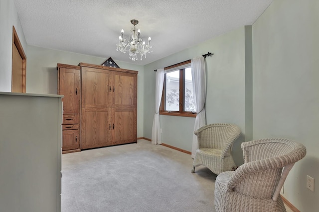 sitting room with an inviting chandelier, light carpet, and a textured ceiling