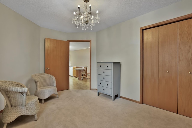 sitting room with a textured ceiling, light colored carpet, and a notable chandelier