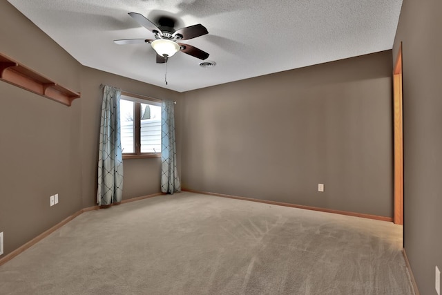 carpeted spare room with ceiling fan and a textured ceiling