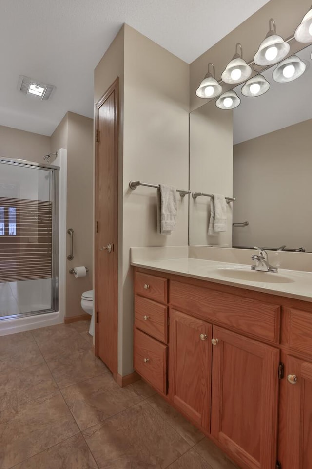 bathroom featuring vanity, toilet, and an enclosed shower